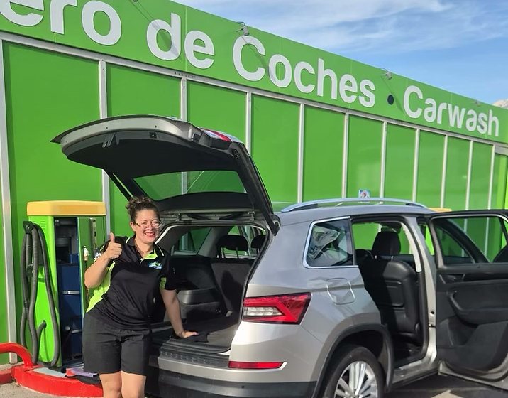 Empleada de Eco Carwash limpiando el maletero de un SUV gris
